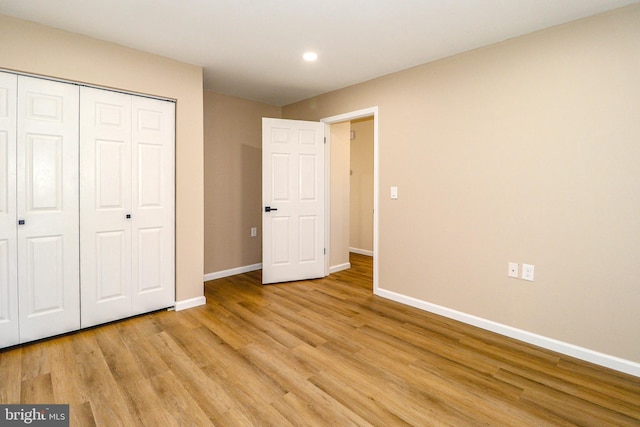 unfurnished bedroom featuring light wood finished floors, recessed lighting, a closet, and baseboards