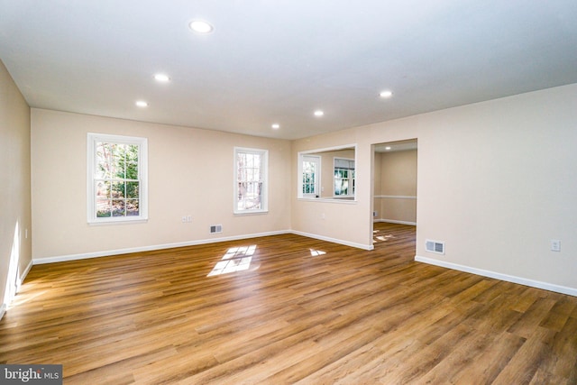 spare room with recessed lighting, visible vents, plenty of natural light, and light wood finished floors