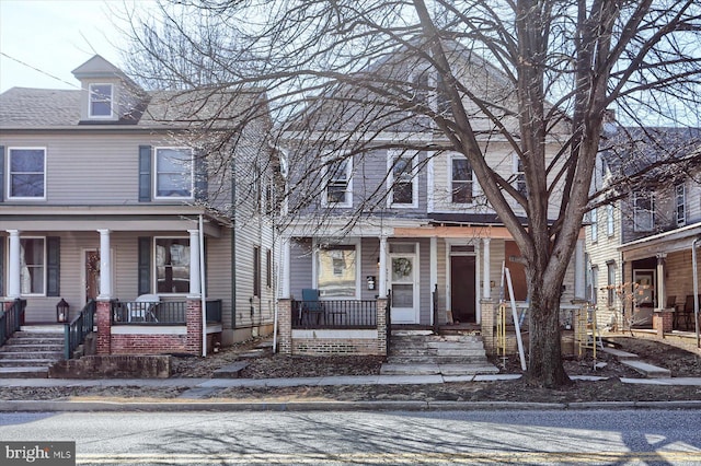 american foursquare style home featuring a porch