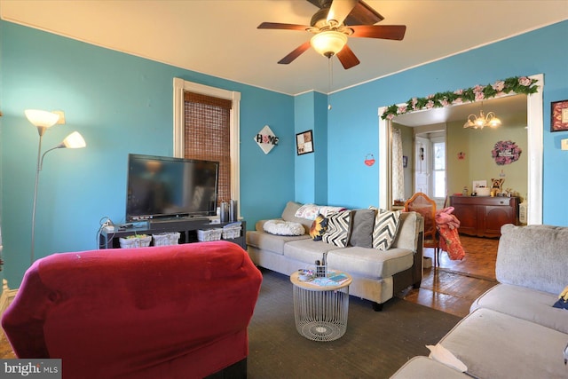 living room with ceiling fan with notable chandelier and wood finished floors