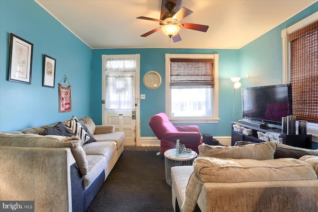 living room featuring a healthy amount of sunlight, baseboards, and ceiling fan