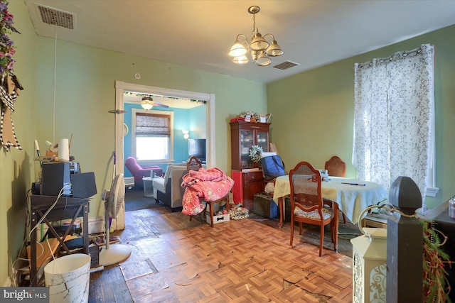 dining space with a notable chandelier, visible vents, and parquet flooring