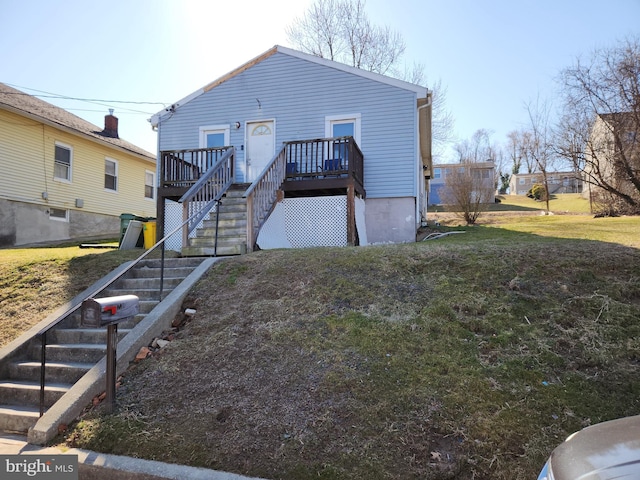 back of house featuring a deck, stairs, and a yard