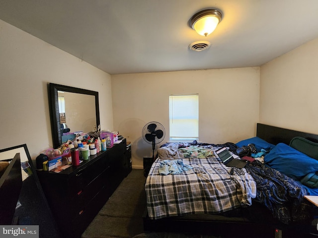 bedroom featuring visible vents and dark carpet