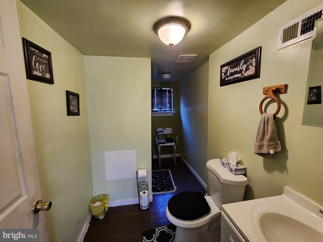 bathroom featuring visible vents, toilet, baseboards, and wood finished floors