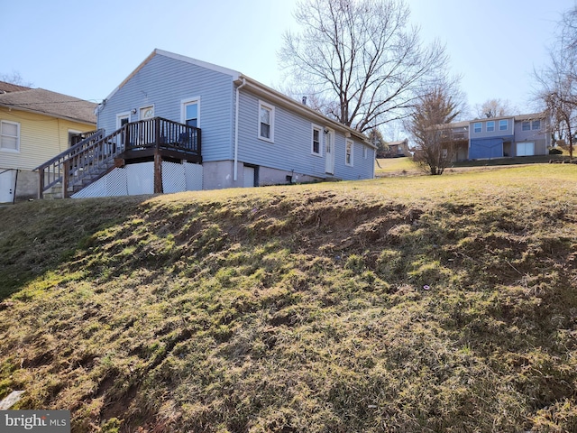 back of property featuring stairs, a yard, and a wooden deck