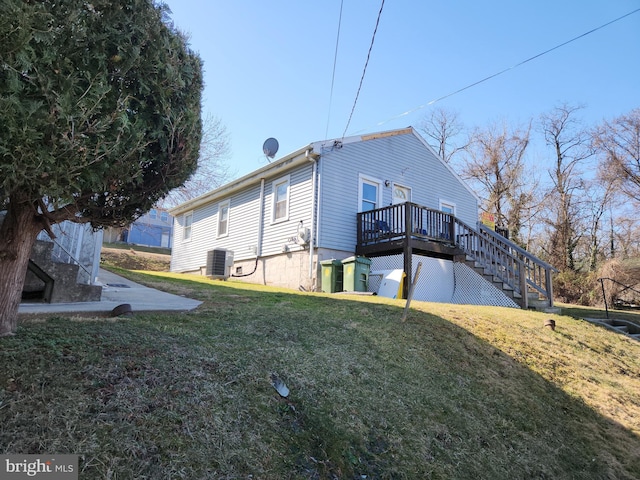 back of property with a wooden deck, central AC, stairs, and a yard