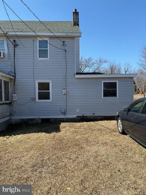 view of side of property with a lawn and a chimney