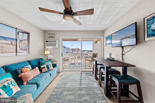 living room with light wood-style floors, a ceiling fan, and a wall mounted AC