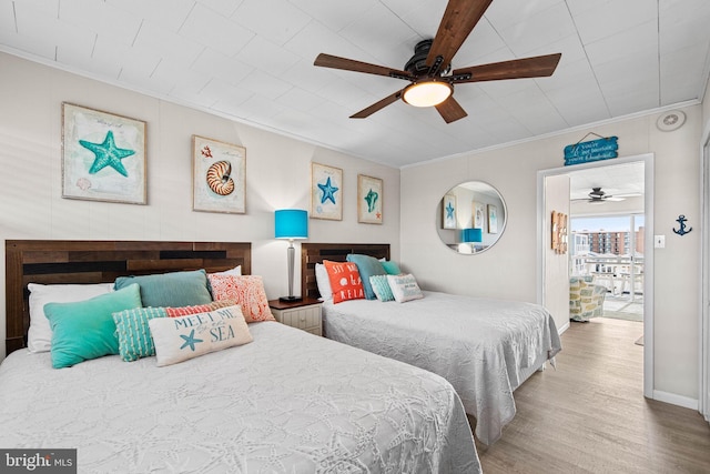 bedroom featuring ornamental molding, baseboards, a ceiling fan, and wood finished floors