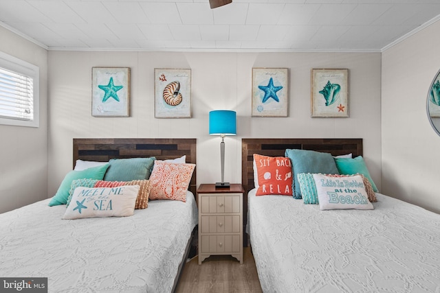 bedroom featuring crown molding and wood finished floors