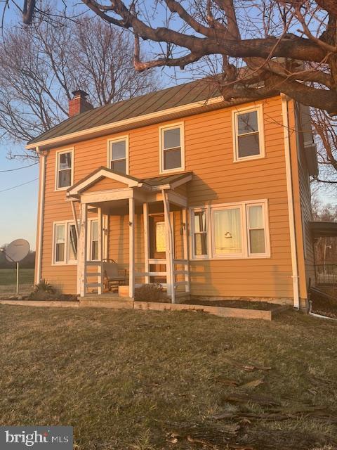 view of front facade featuring a chimney and a front yard