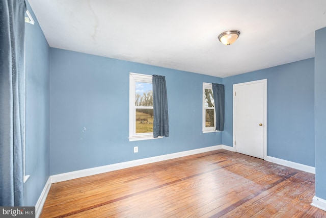 unfurnished room featuring baseboards and wood finished floors