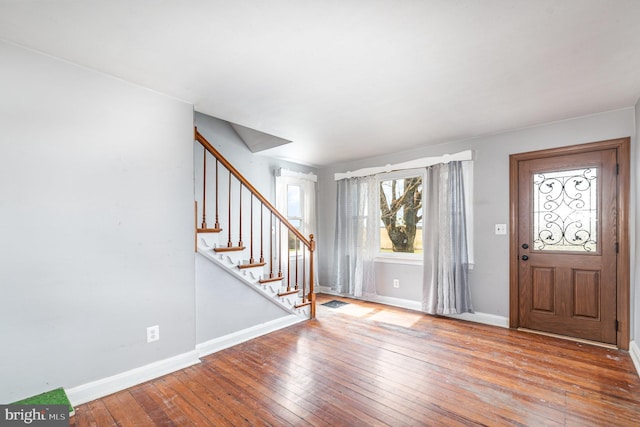 foyer entrance featuring stairs, baseboards, and hardwood / wood-style flooring