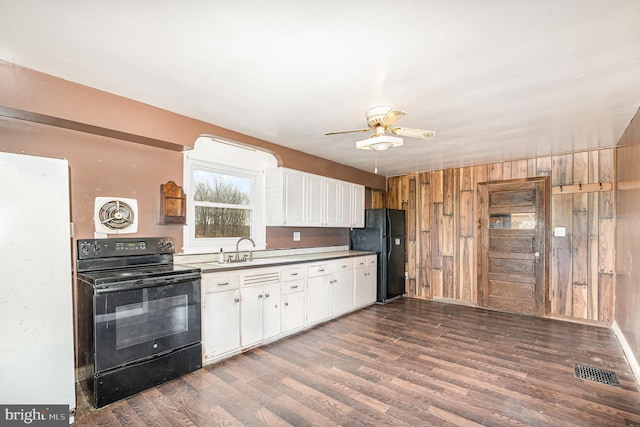 kitchen featuring visible vents, dark wood-style flooring, black appliances, and a sink