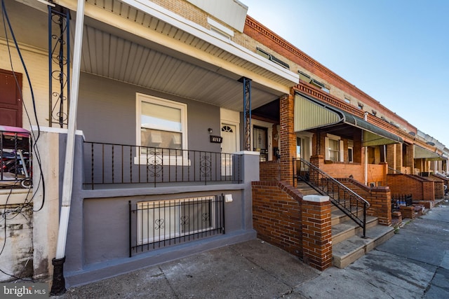 exterior space featuring brick siding and covered porch