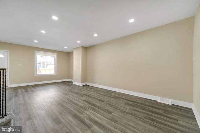 unfurnished room with dark wood-style floors, visible vents, recessed lighting, and baseboards