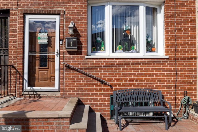 view of exterior entry with brick siding