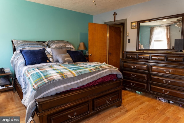 bedroom featuring a textured ceiling and light wood finished floors