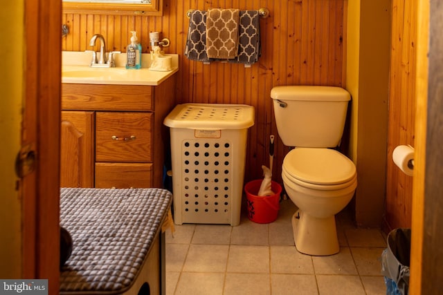 bathroom featuring tile patterned floors, toilet, wood walls, and vanity