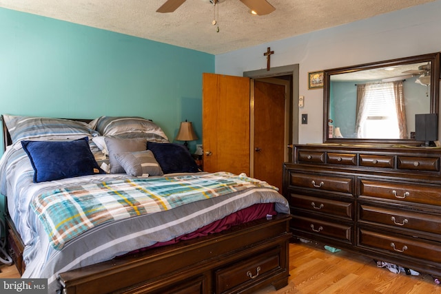 bedroom with light wood-type flooring, a textured ceiling, and ceiling fan