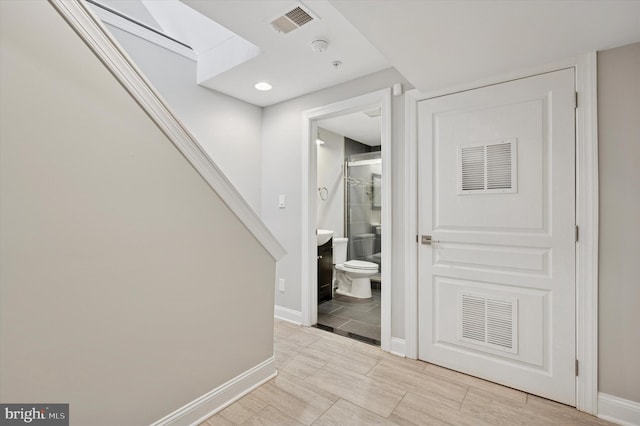 hallway featuring baseboards and visible vents