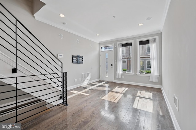foyer featuring crown molding, stairs, baseboards, visible vents, and wood finished floors