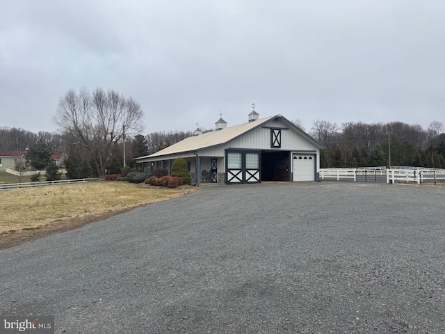 exterior space featuring an outbuilding, driveway, a garage, and fence