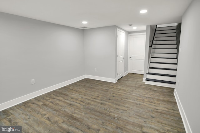 finished basement with visible vents, baseboards, dark wood finished floors, stairway, and recessed lighting