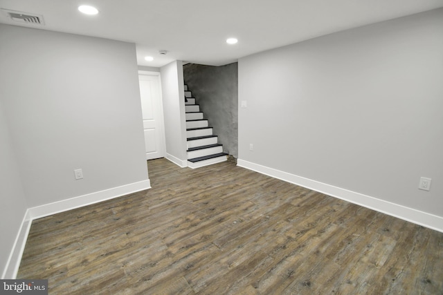 finished below grade area featuring visible vents, baseboards, stairs, recessed lighting, and dark wood-style flooring