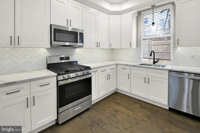 kitchen featuring dark wood finished floors, appliances with stainless steel finishes, white cabinetry, and a sink