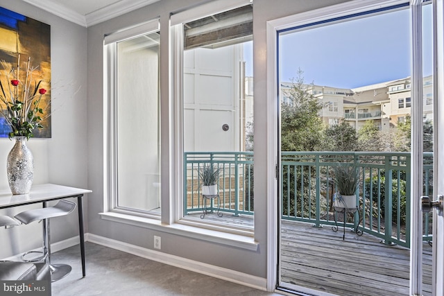 doorway featuring crown molding and baseboards