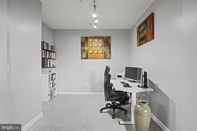 office space featuring baseboards and rail lighting