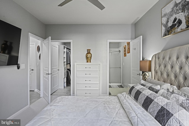 bedroom with a walk in closet, ensuite bath, a ceiling fan, and a closet