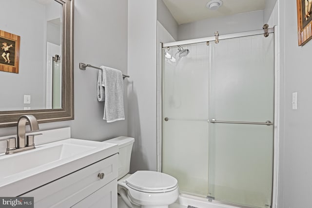 full bath featuring vanity, toilet, and a shower stall