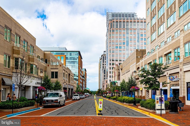 view of street featuring a city view, curbs, street lighting, and sidewalks