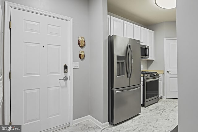 kitchen featuring marble finish floor, white cabinetry, stainless steel appliances, light countertops, and baseboards