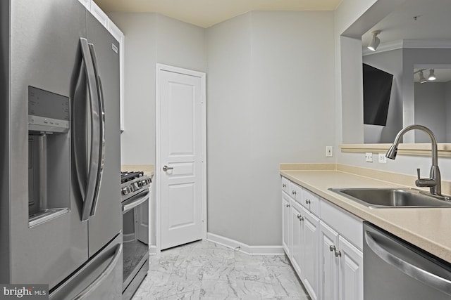 kitchen with baseboards, stainless steel appliances, marble finish floor, white cabinetry, and a sink