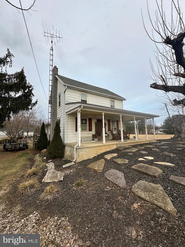 view of front of property with covered porch and a chimney