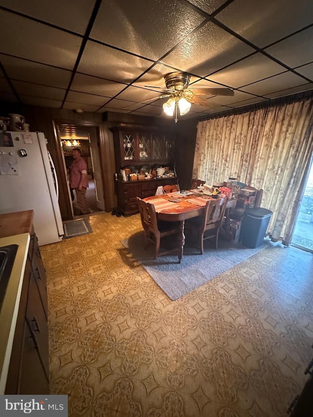 dining room with a drop ceiling and ceiling fan