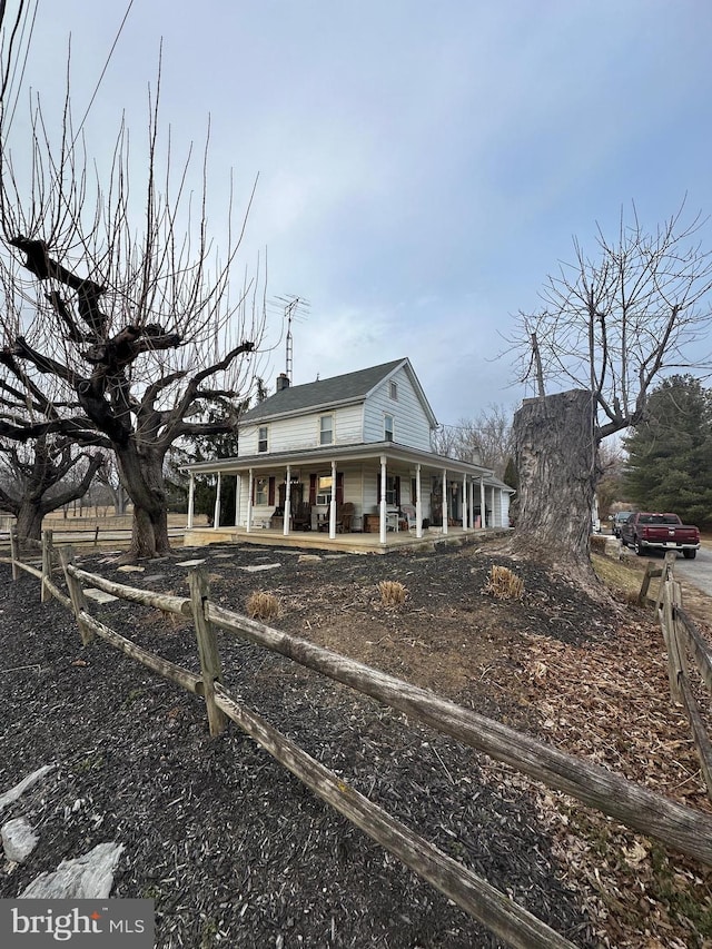 view of front facade featuring a porch and a chimney