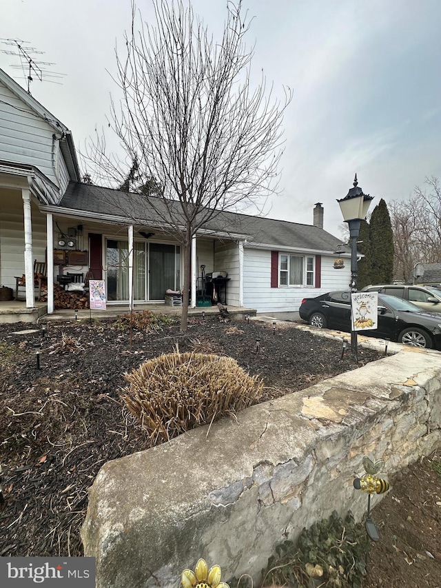 view of front of home featuring a porch and a chimney