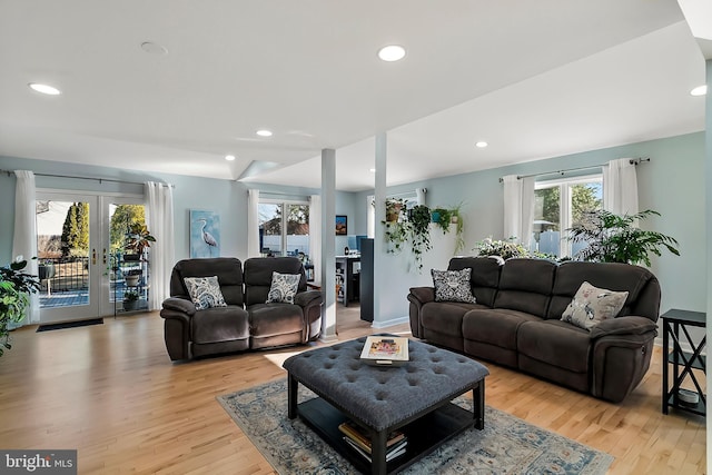 living area with recessed lighting, french doors, and light wood-style floors