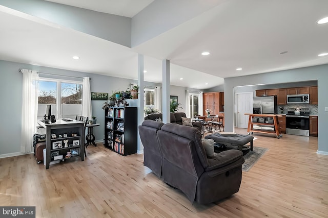 living area with recessed lighting, light wood-style floors, and vaulted ceiling