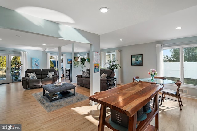 living area with recessed lighting, french doors, light wood-style floors, and a healthy amount of sunlight