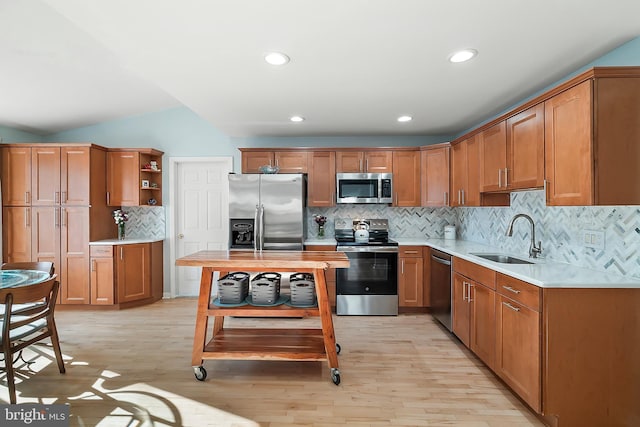 kitchen with light wood-style flooring, a sink, open shelves, appliances with stainless steel finishes, and light countertops