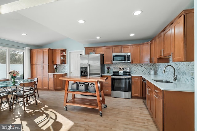 kitchen featuring a sink, open shelves, appliances with stainless steel finishes, brown cabinetry, and light countertops