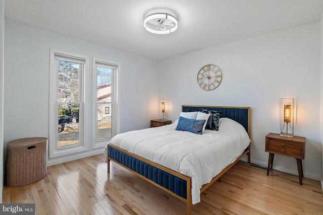 bedroom with baseboards and light wood-type flooring