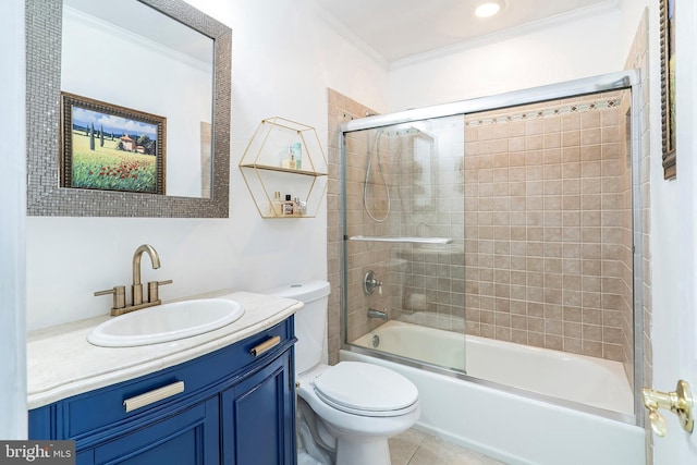 bathroom featuring vanity, bath / shower combo with glass door, tile patterned flooring, crown molding, and toilet