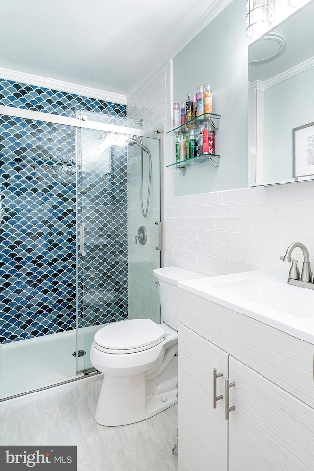 bathroom featuring toilet, tile walls, ornamental molding, and a shower stall